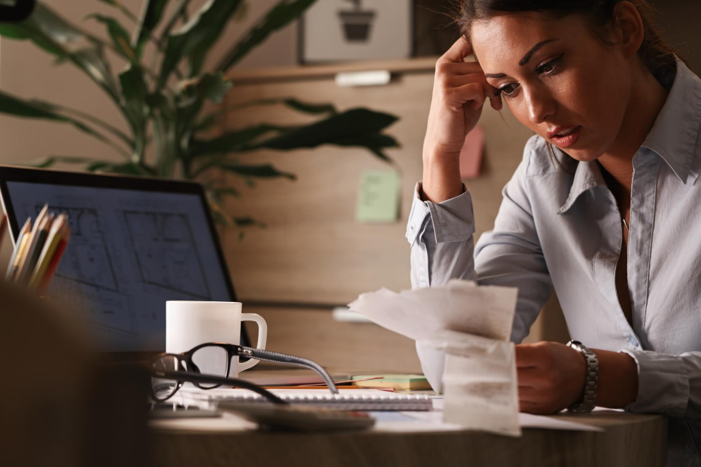 businesswoman-feeling-worried-about-financial-debts-analyzing-bills-while-working-office.jpg